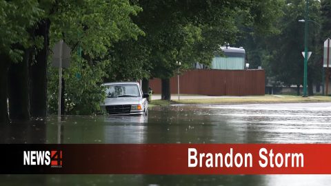 A vehicle is caught in flooded street in Brandon